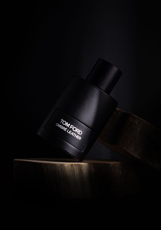 Flacon de parfum noir élégant sur fond sombre, évoquant le luxe et le raffinement