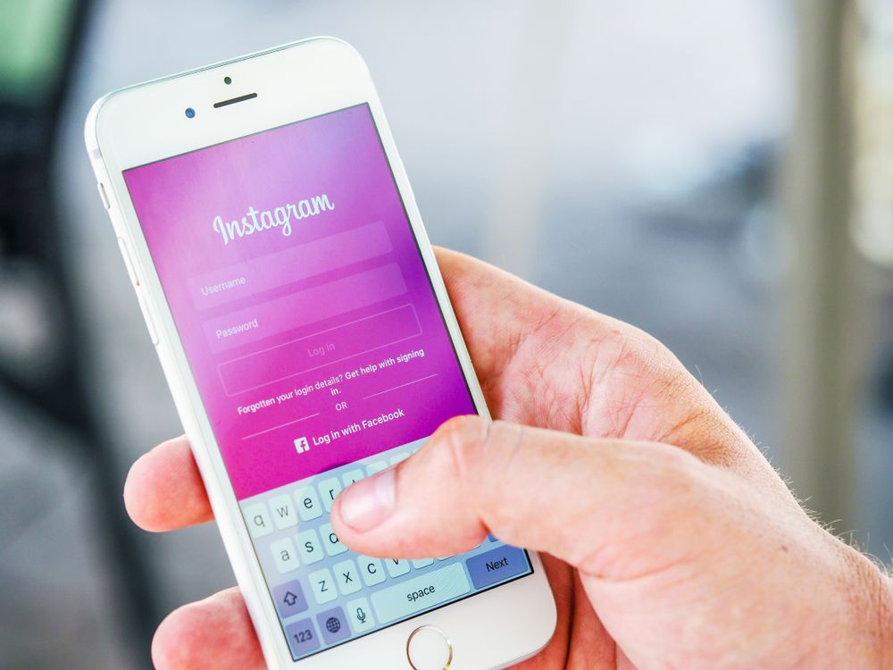Person holding a phone while logging in to the Instagram application