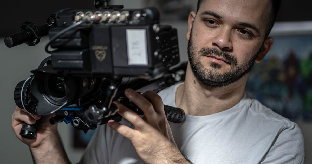 Cameraman using a professional video camera indoors for content production