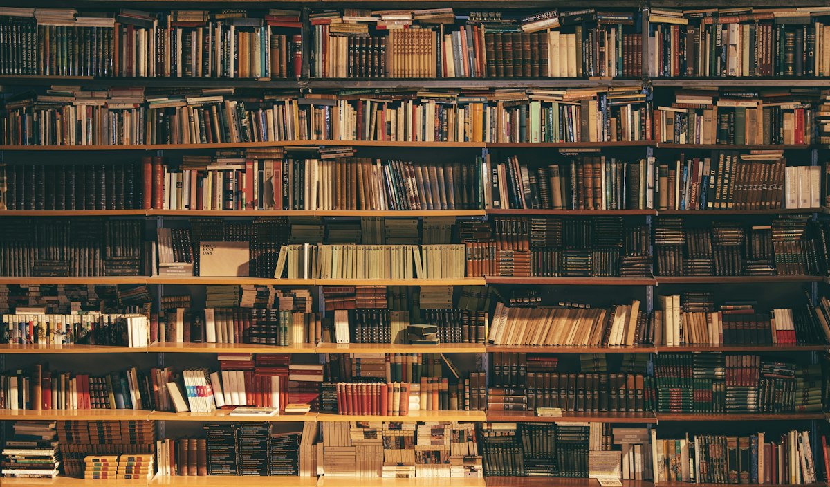Libros antiguos apilados en los estantes de madera de una biblioteca clásica