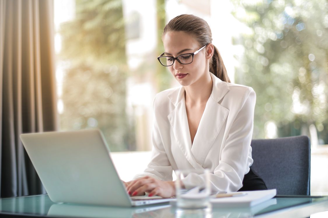 Emprendedora concentrada trabajando en su laptop en un espacio de trabajo moderno