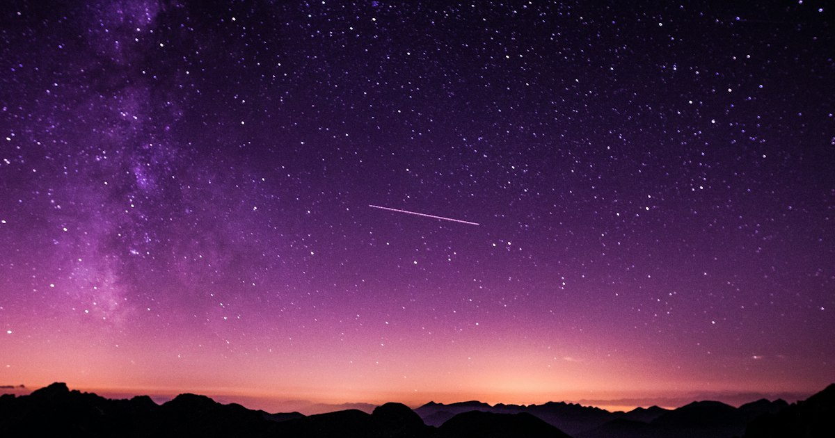 Cielo nocturno estrellado sobre un horizonte oscuro, símbolo de la pregunta por el propósito del universo