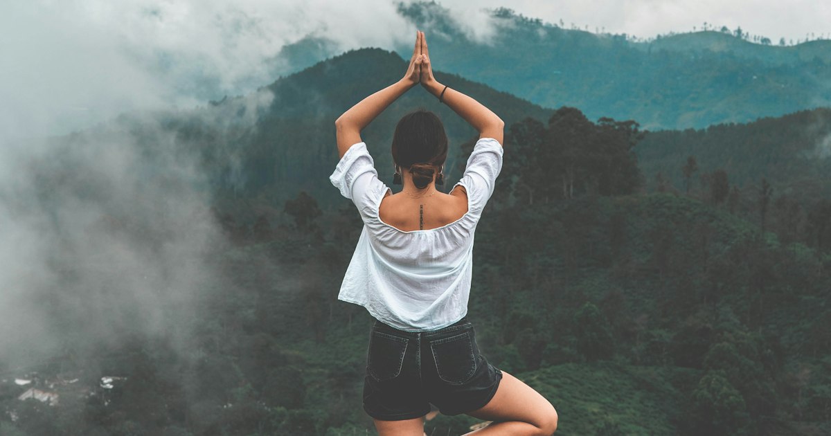 Persona en postura de meditación en un entorno natural sereno