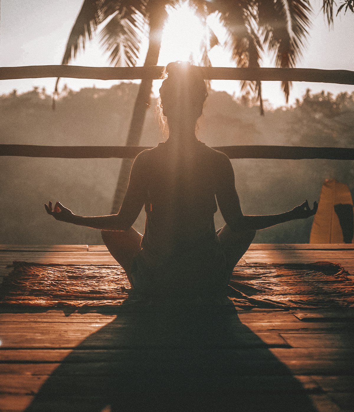 Persona meditando sentada frente a un paisaje natural tranquilo al amanecer