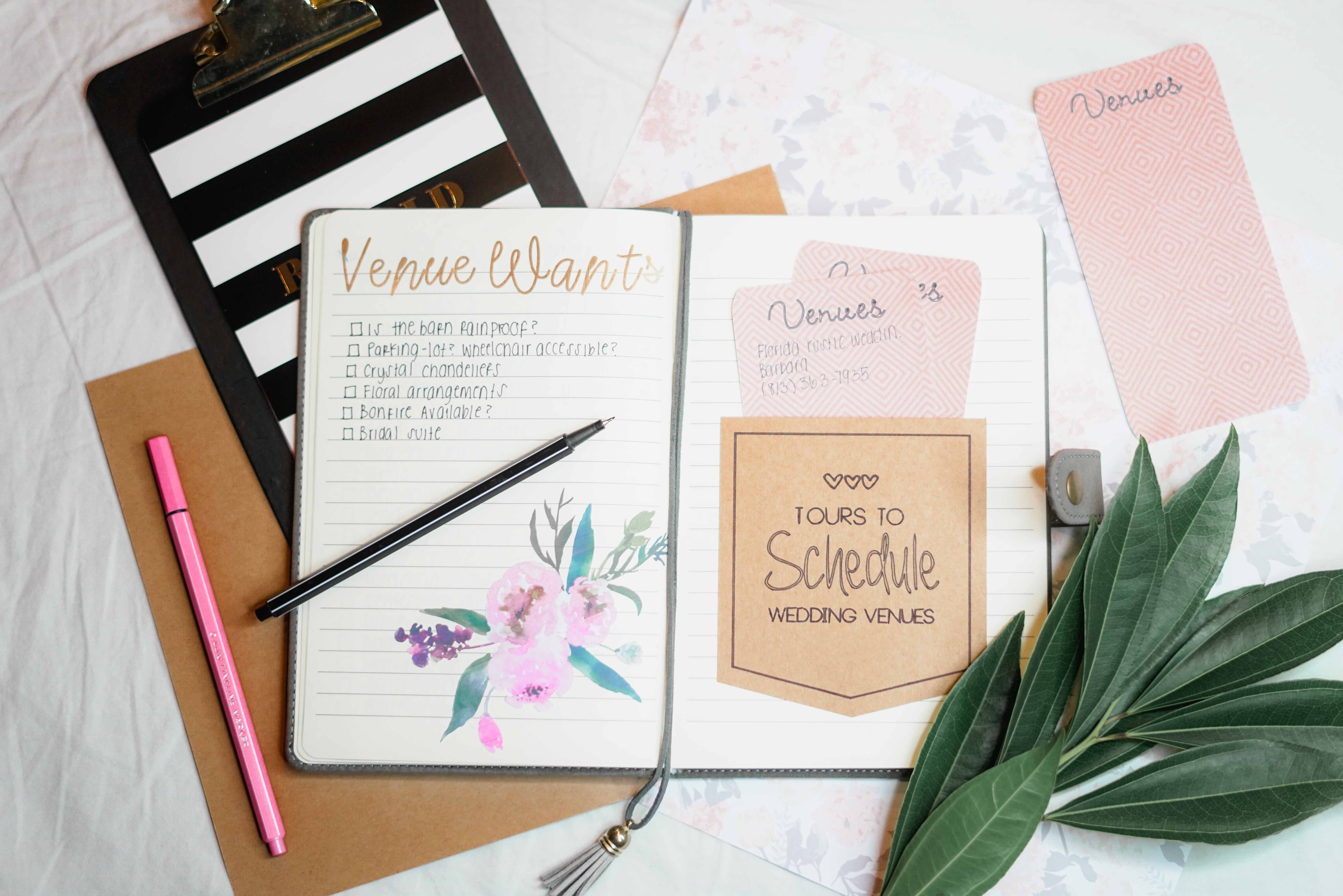 Wedding planning materials and stationery laid out on a desk