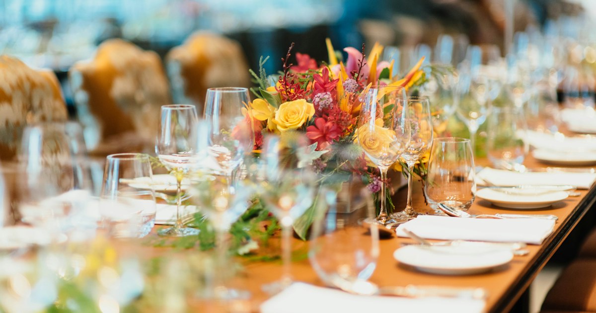 Elegant hotel ballroom wedding reception with crystal chandeliers and round tables set for a formal dinner