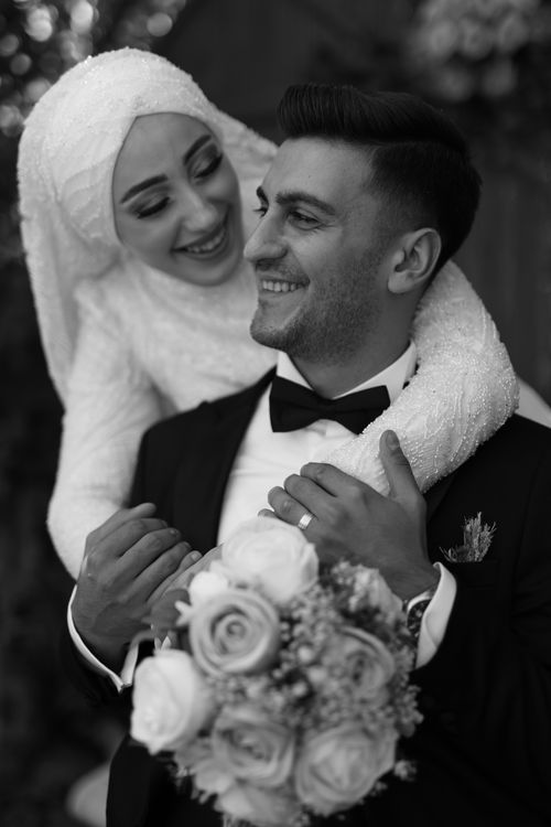 A married couple celebrates their wedding day outdoors with joyful expressions
