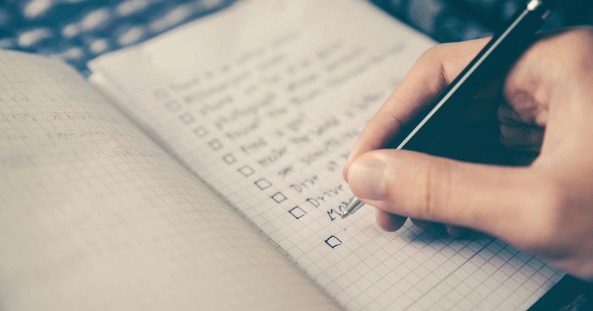 Checklist and planning notebook on a desk with a pen for organizing event tasks