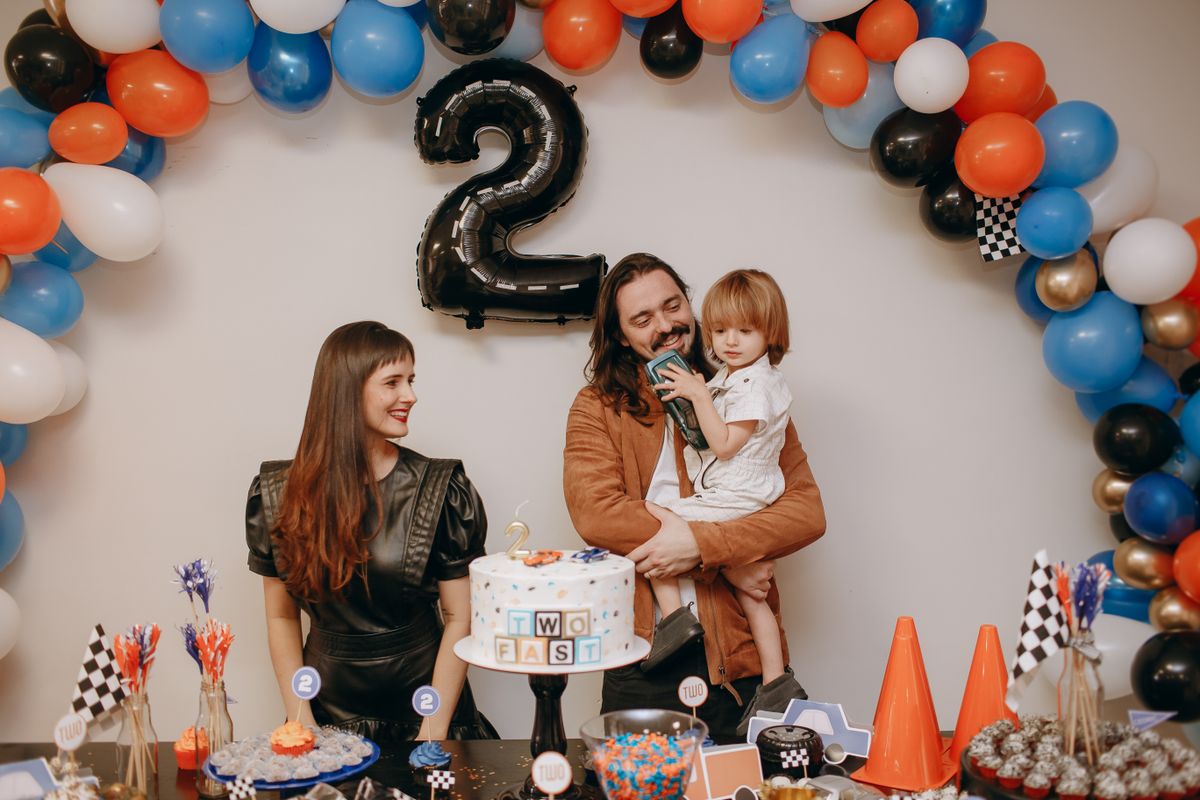 A family celebrating a child's birthday at home with balloons and cake