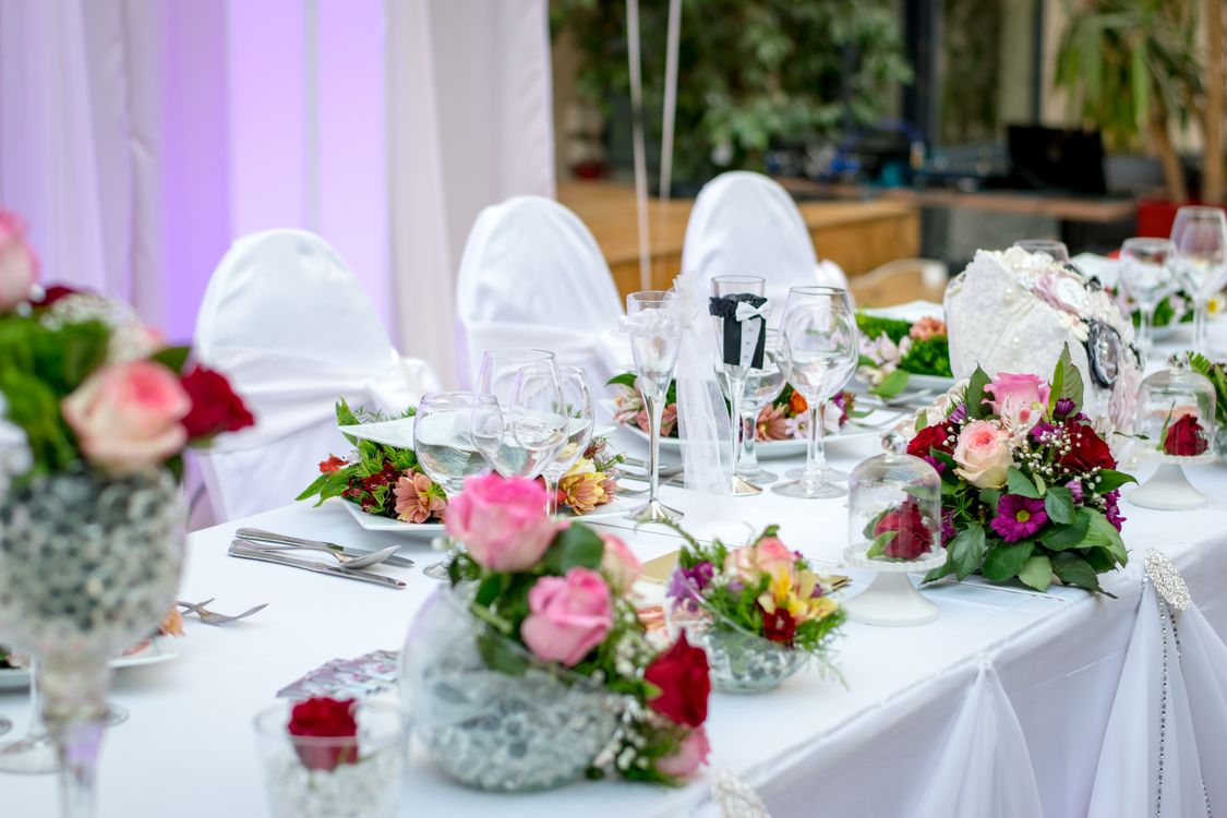 Fine dining wedding table setting with floral arrangements and wine glasses