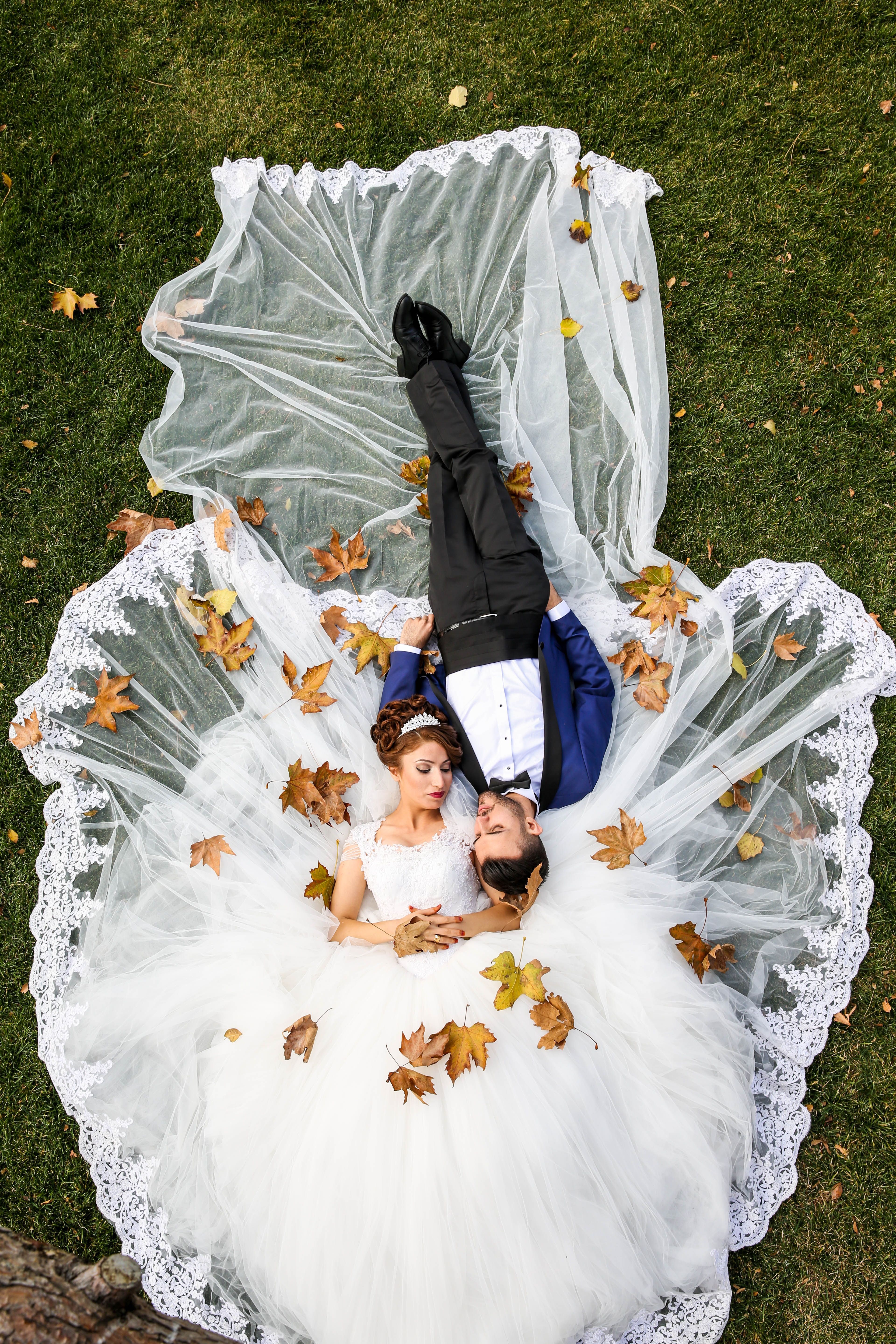 A couple holding a wedding bouquet outdoors