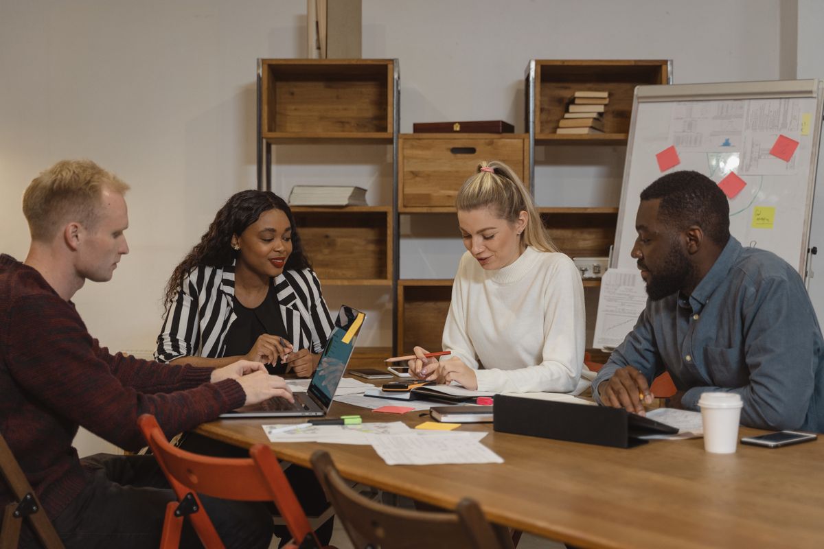 A diverse team collaborating with laptops in a contemporary office, focused on problem solving
