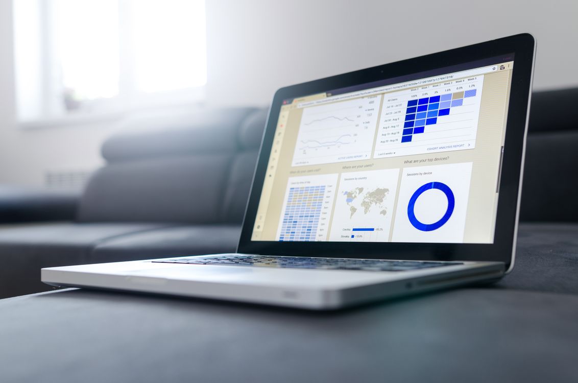 Laptop and devices showing business analytics and charts on screen