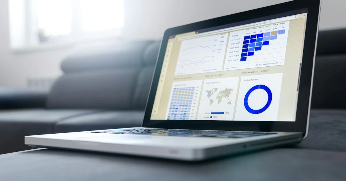 Professional workspace with multiple monitors showing data analytics and business metrics