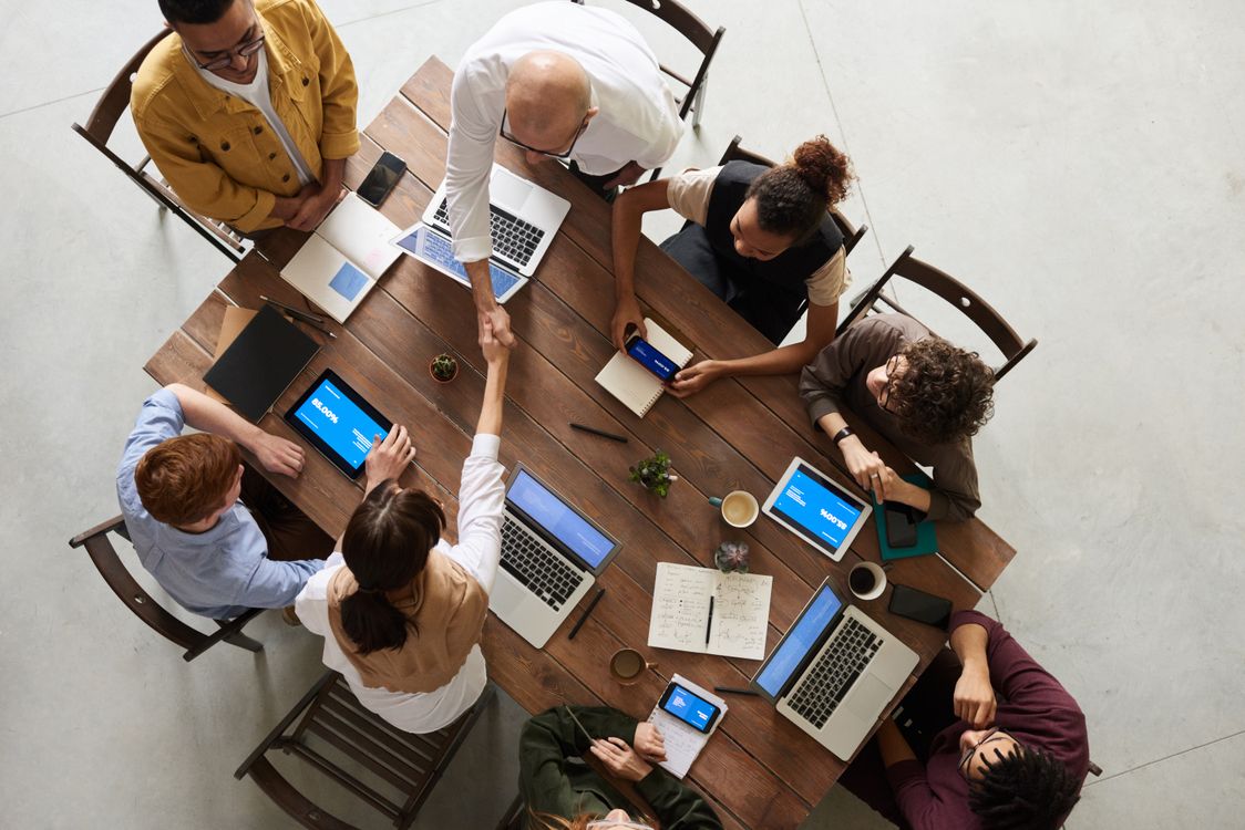 A team collaborating around a table with laptops in a modern office