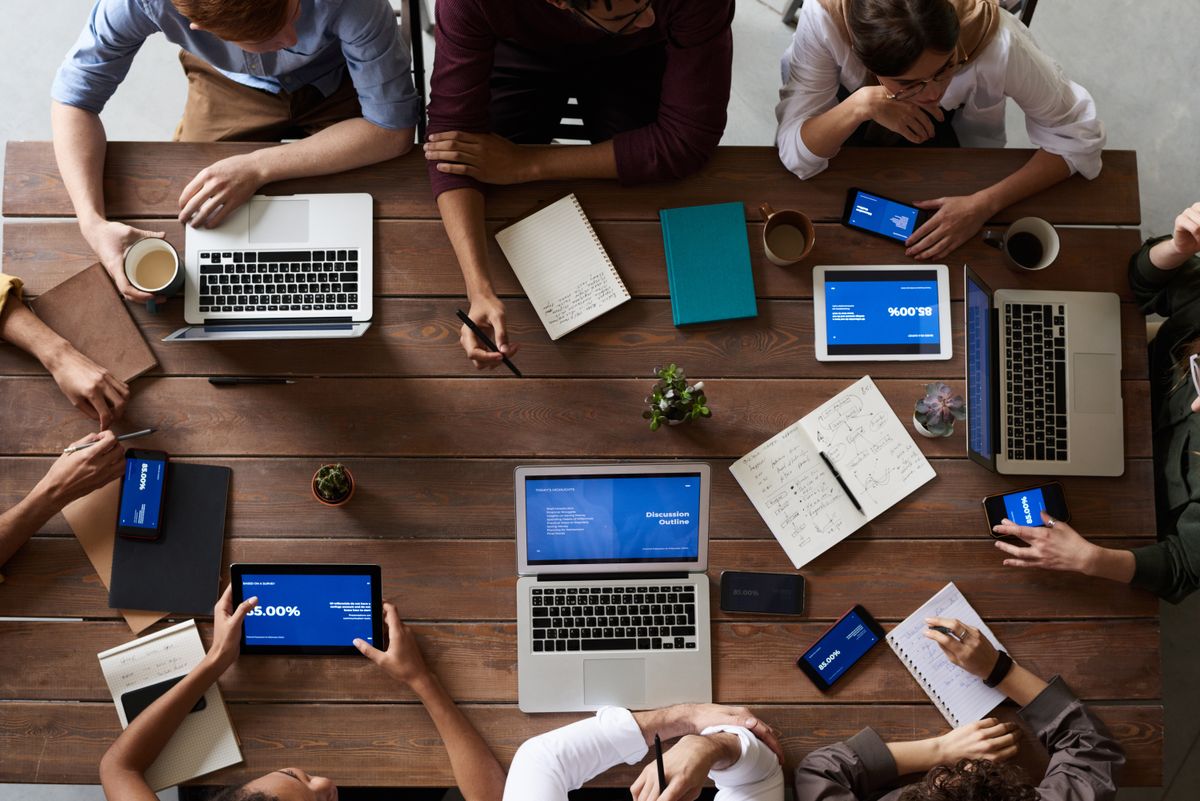 Team members reviewing data on screens during a strategy meeting in an open office