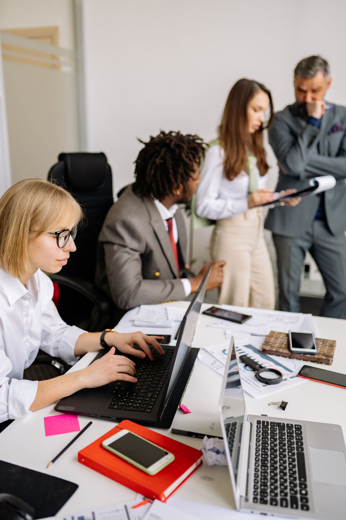 Office team gathered around a table engaged in collaborative discussion in a modern meeting room