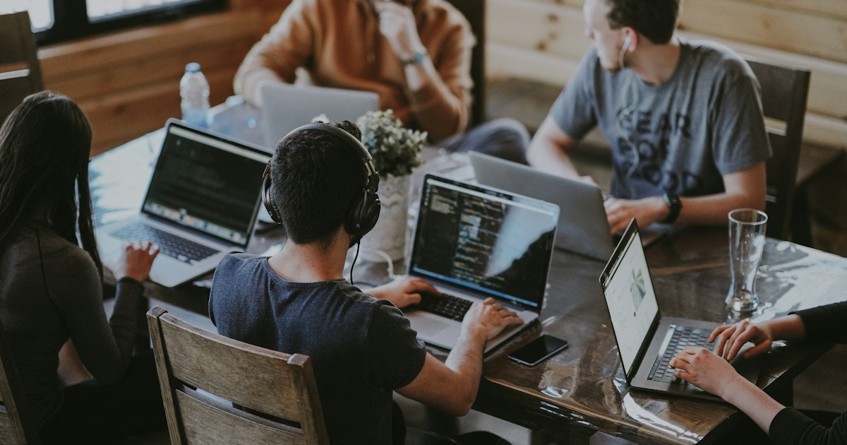 Operations team collaborating around a laptop in a modern office