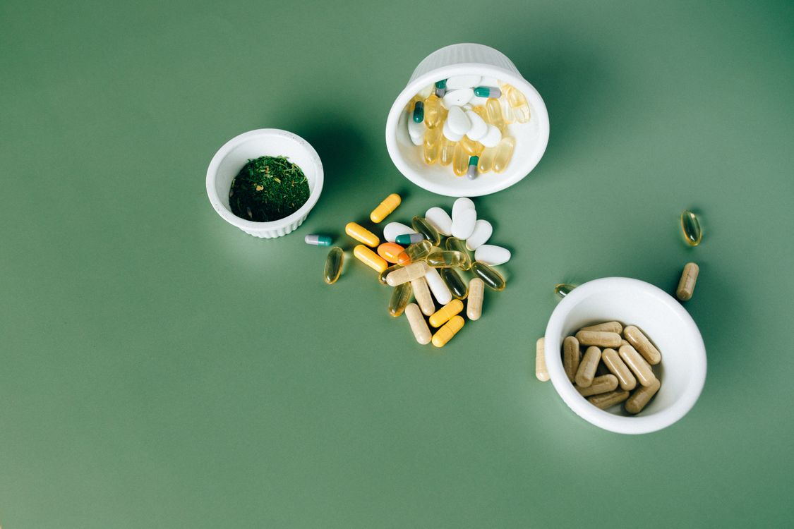 Flat lay of herbal supplement capsules and natural ingredients