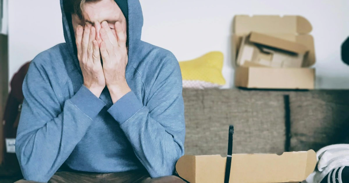 Person resting their head on their hand at a laptop, looking mentally tired