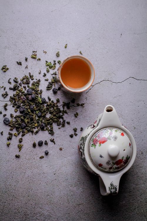 Top-down view of oolong tea with a teapot and loose tea leaves