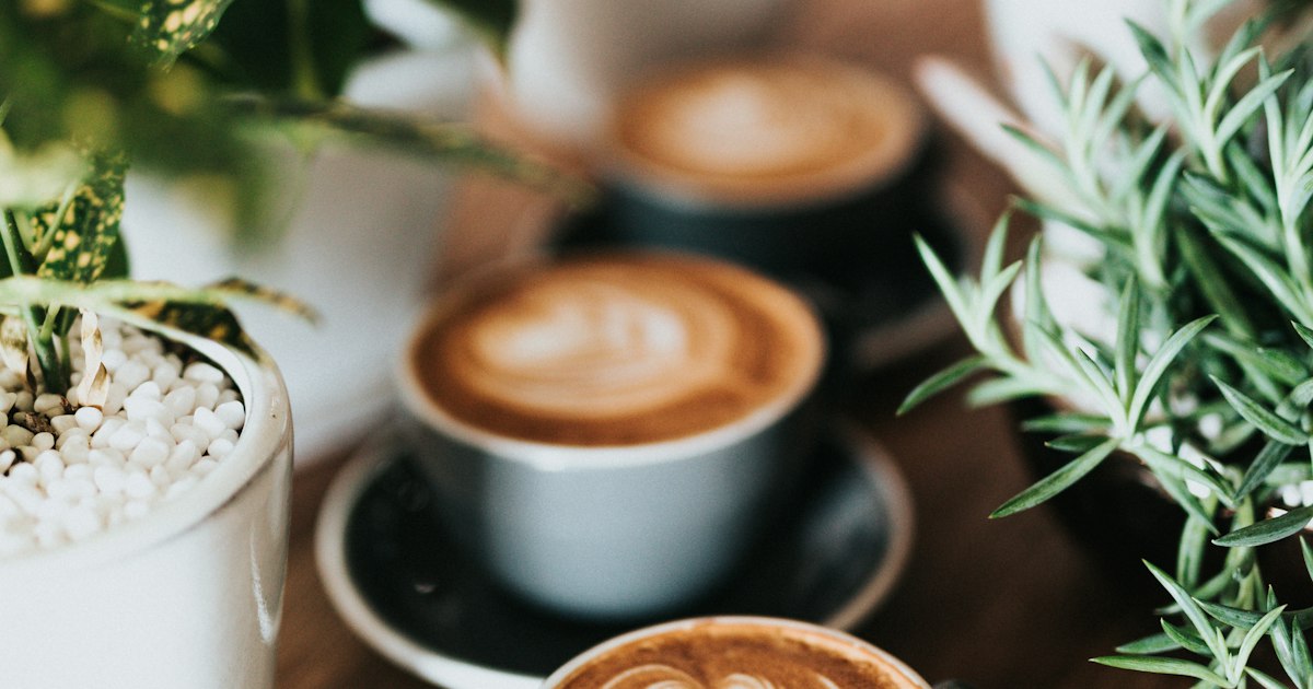 A white cup of coffee with delicate latte art viewed from above