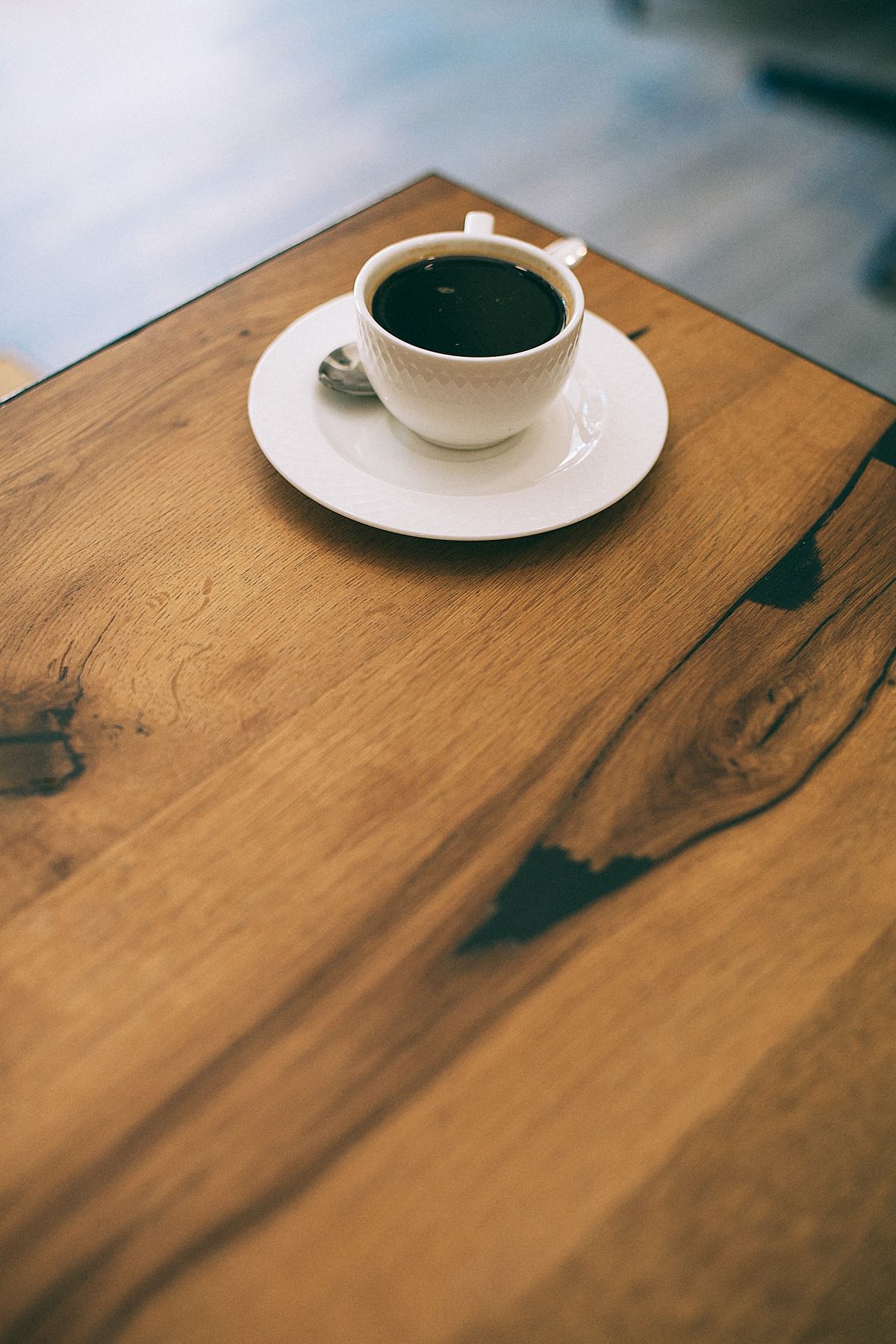 Warm cup of coffee on a rustic wooden table in a cozy cafe setting