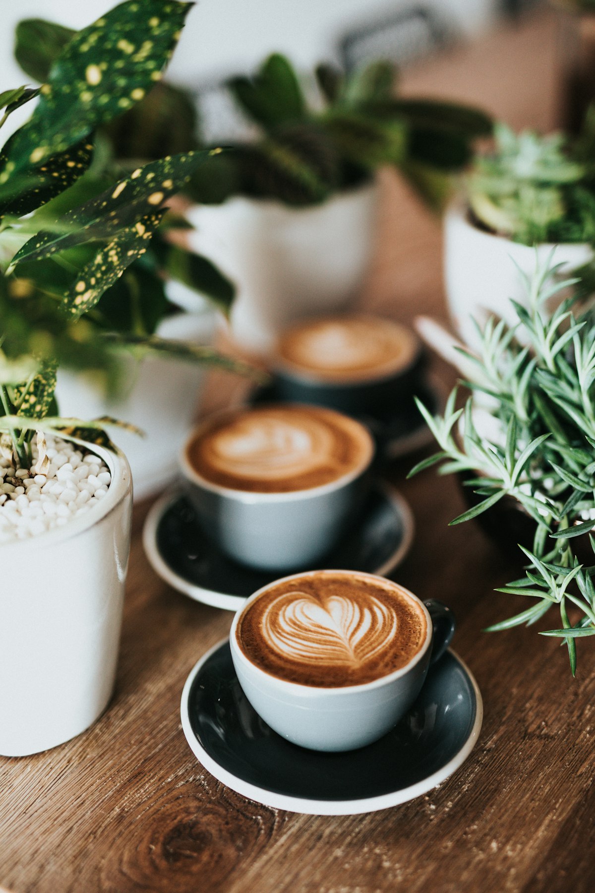 White ceramic cup filled with black coffee on a wooden surface