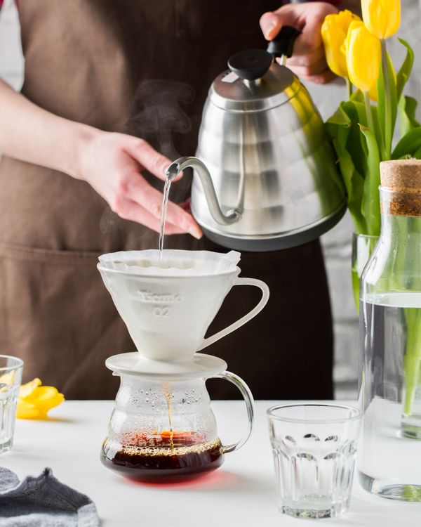 Person pouring water over coffee grounds in a pour-over brewer