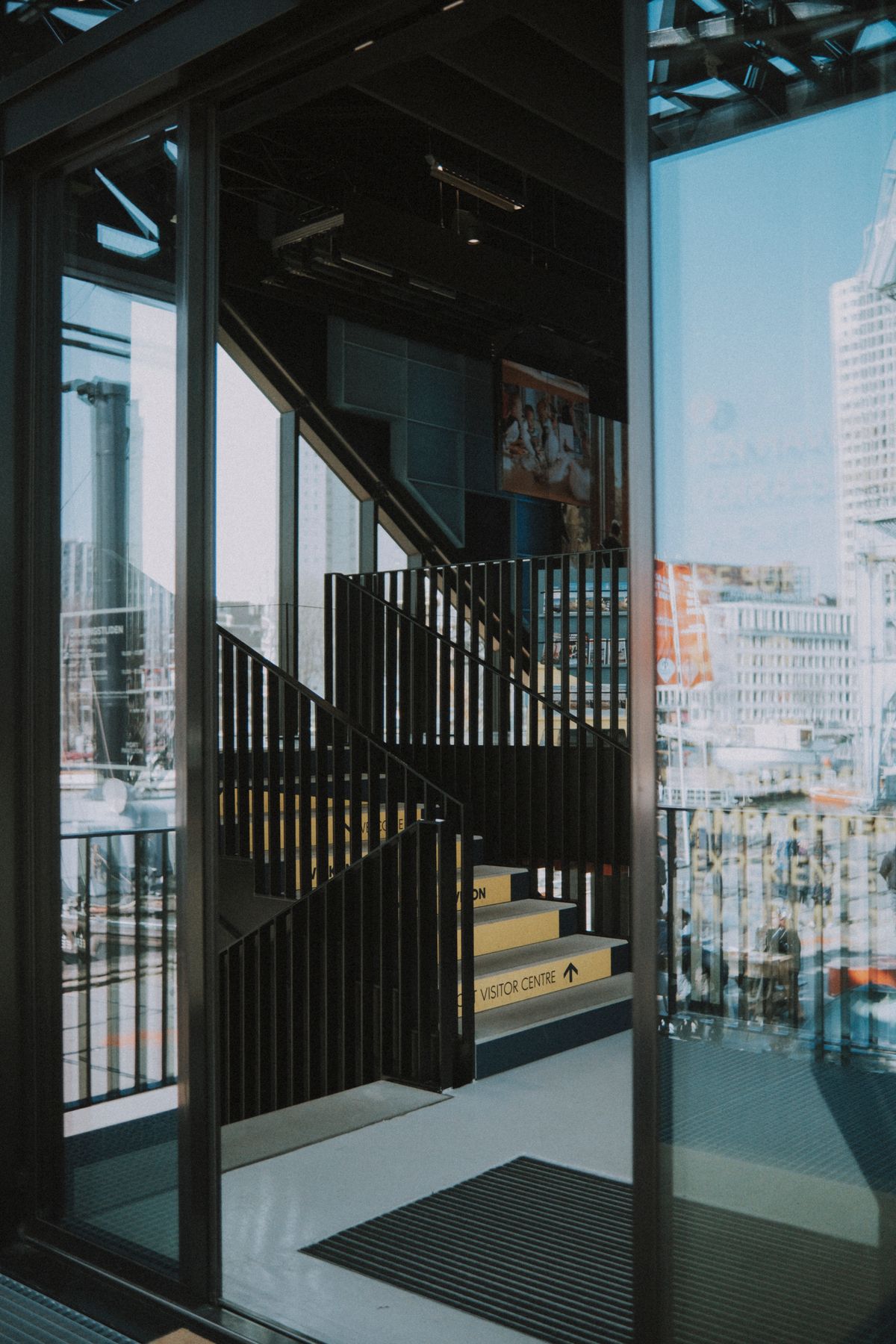 Entrada de vidrio contemporánea a edificio comercial moderno con puertas de cristal