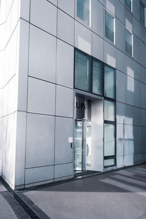 Entrada de cristal a un edificio comercial moderno con puertas automáticas