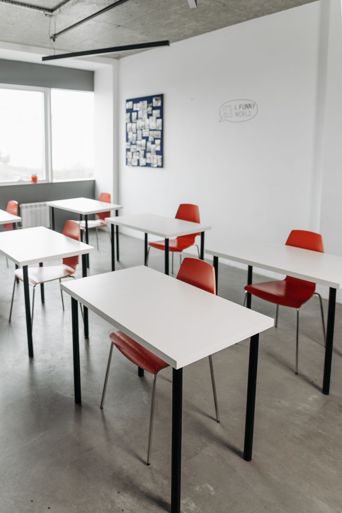 A modern classroom with neatly arranged student desks and chairs facing the teaching area