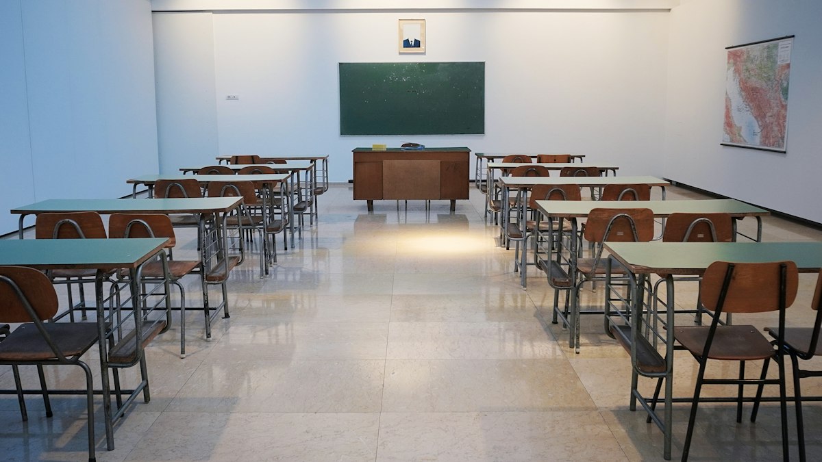 Rows of school desks and chairs in a bright classroom