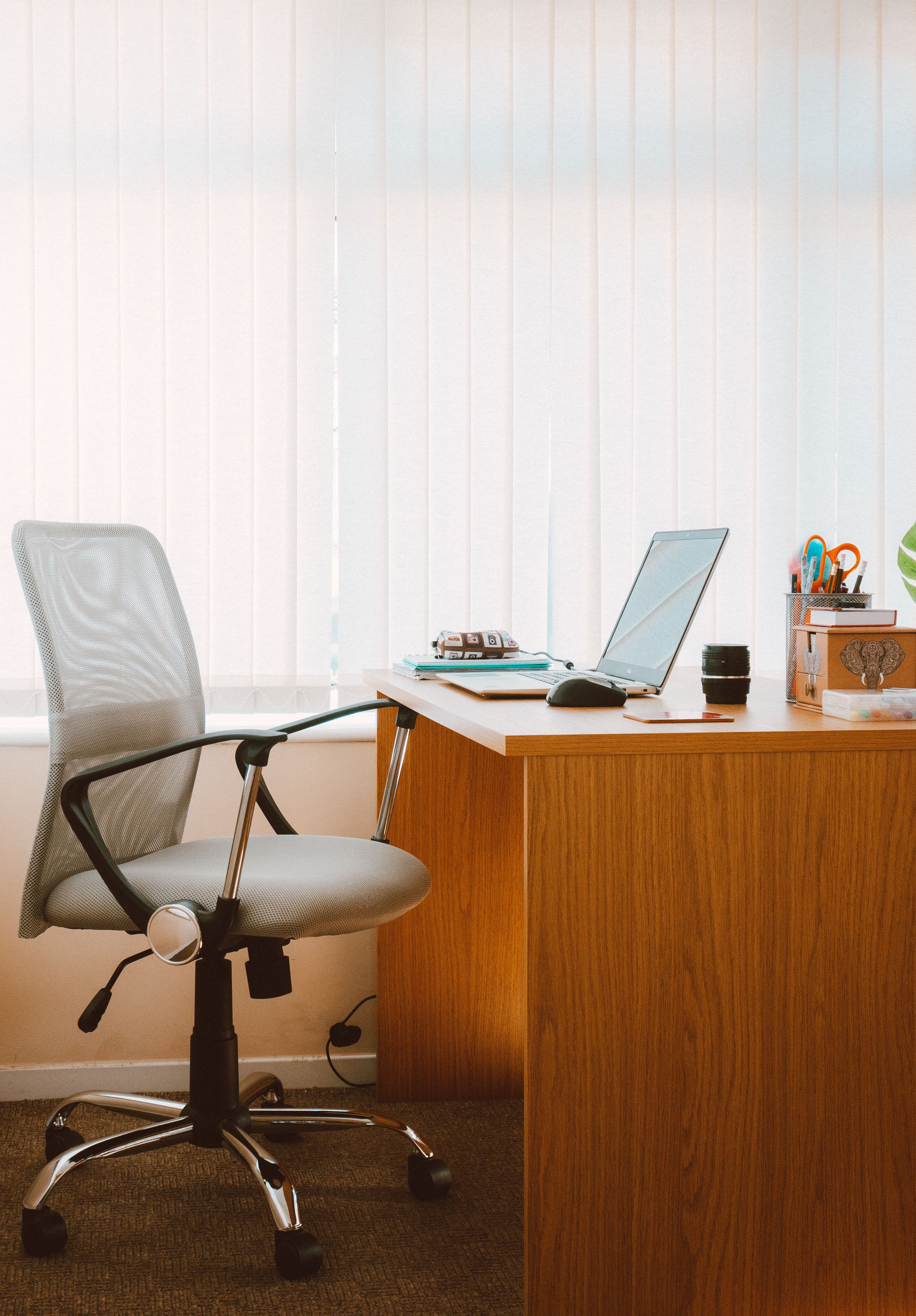 Ergonomic office chair at a glass desk in a bright modern office