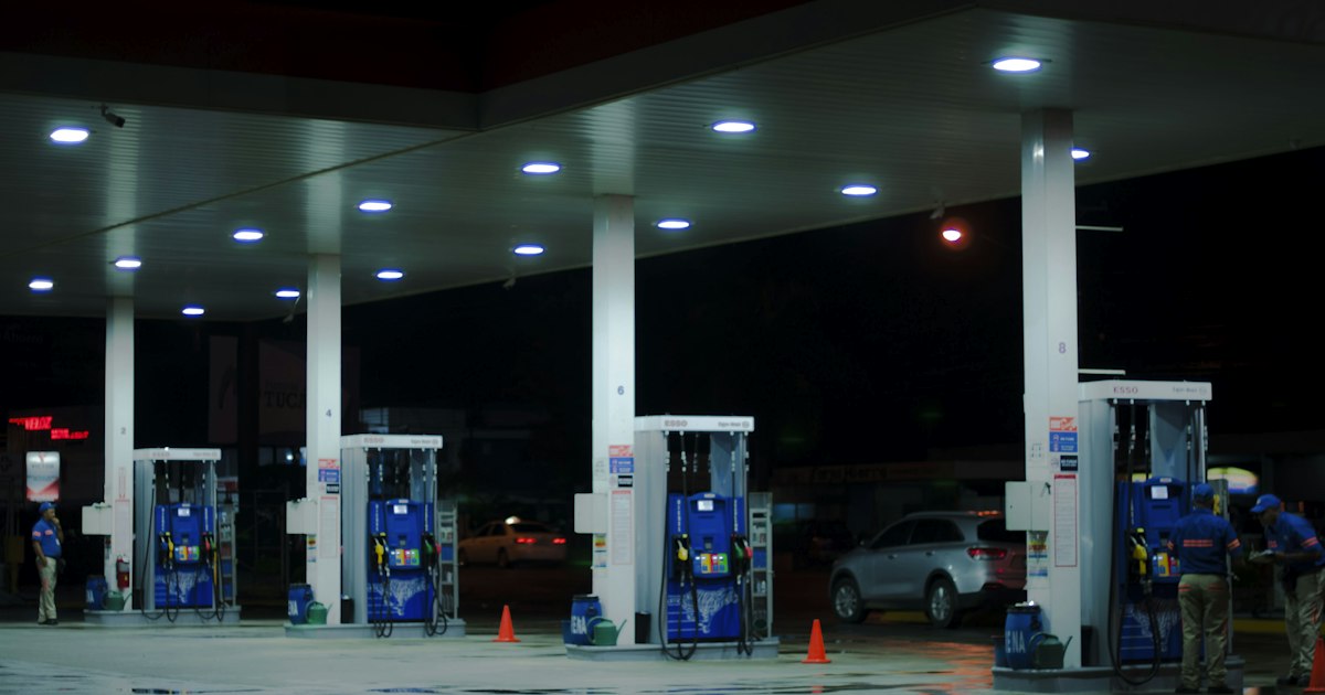 A driver refueling a car at a modern gas station pump