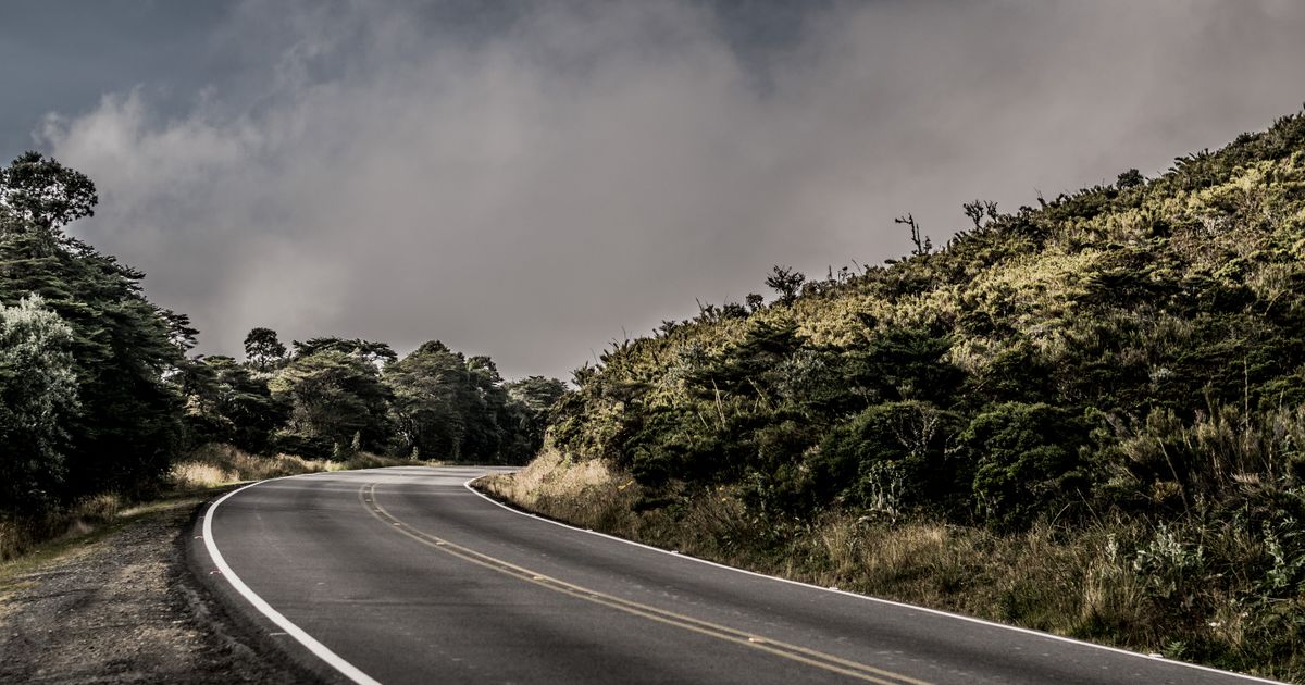 Curved concrete road winding through green grass in Cartago, Costa Rica