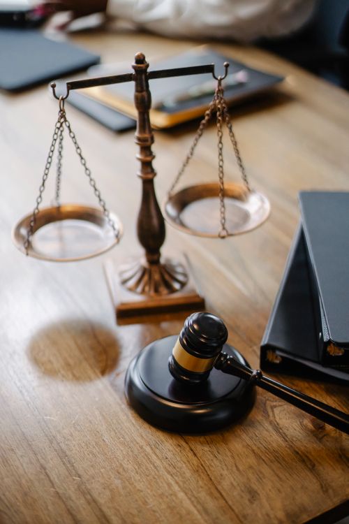 Balança da justiça e martelo de juiz sobre mesa de madeira em escritório jurídico