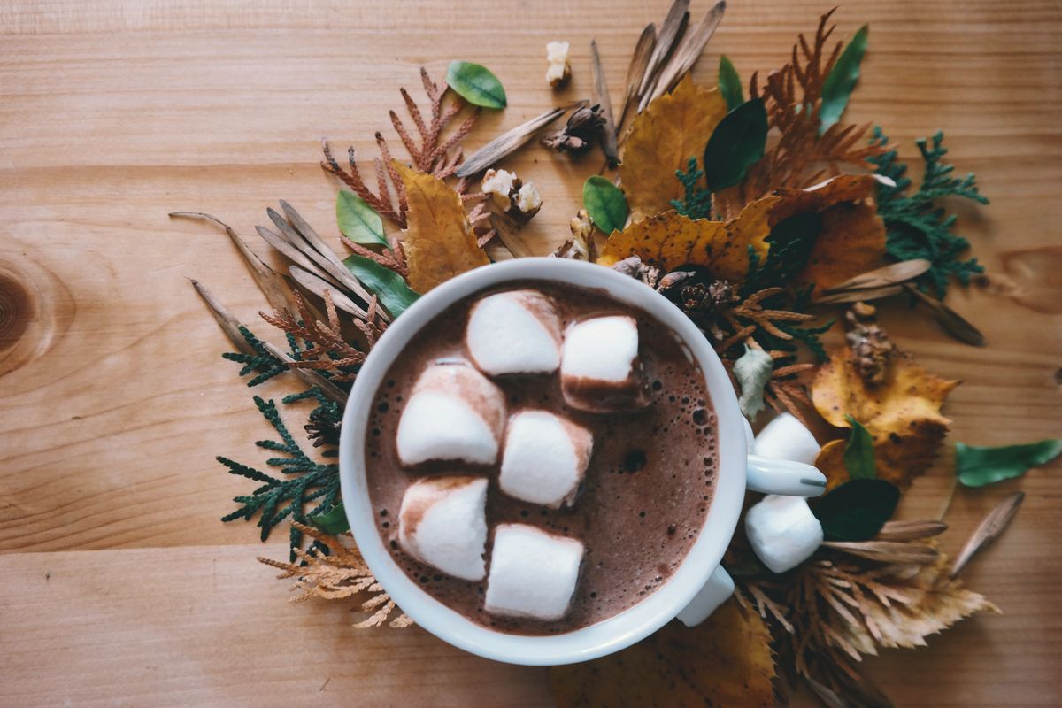 Taza de chocolate caliente con malvaviscos sobre una mesa de madera