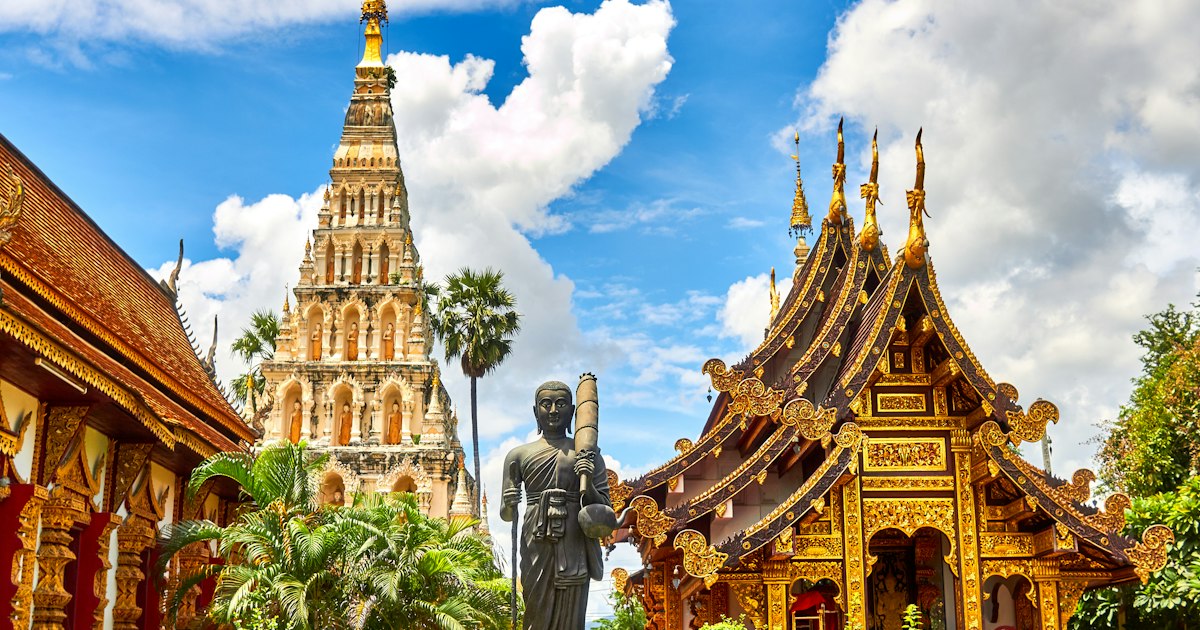 Golden Buddhist temple spire against blue sky in Chiang Mai, Thailand