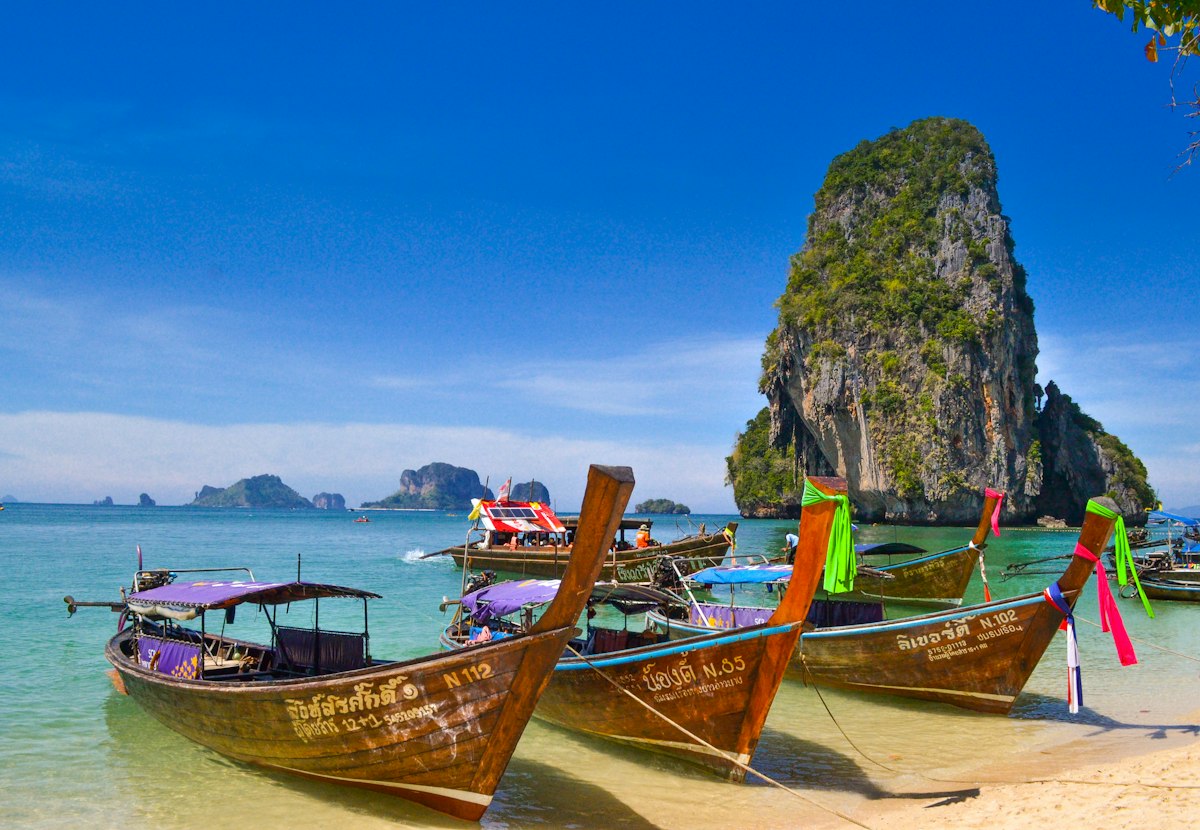 Dramatic limestone karsts rising over a quiet beach at sunrise in Krabi, Thailand