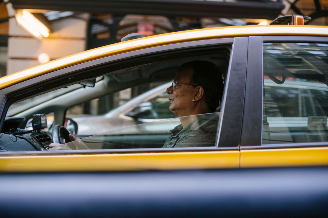 Conductor de taxi profesional al volante de un vehículo en servicio