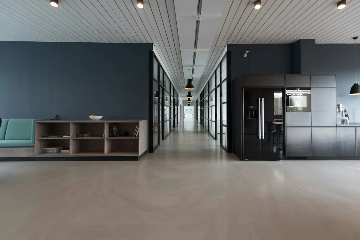 Interior de oficina diáfana con luz natural y diseño de pared contemporáneo