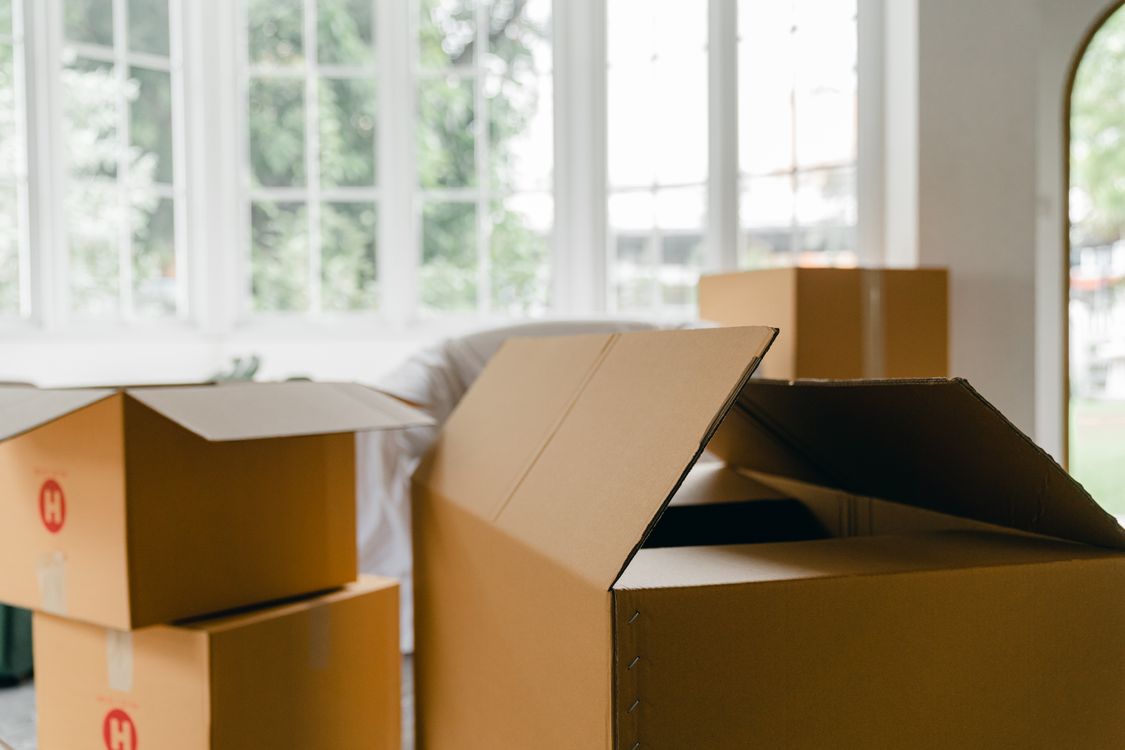 Cajas de mudanza abiertas en medio de una habitación luminosa y vacía