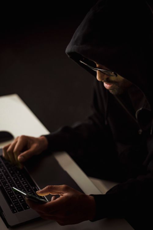 Ciberdelincuente operando dispositivos en la oscuridad durante un ataque de ransomware