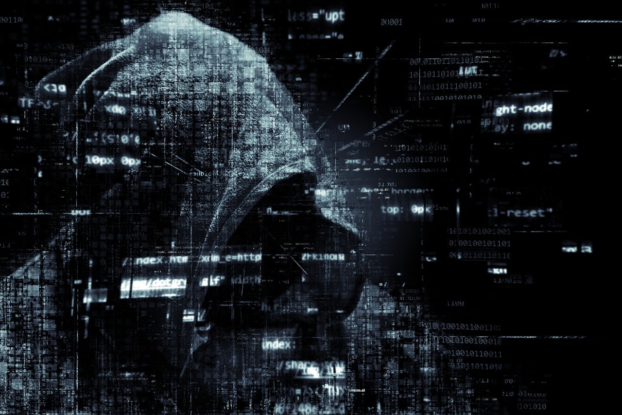 Profesional de ciberseguridad analizando código en múltiples monitores durante un incidente