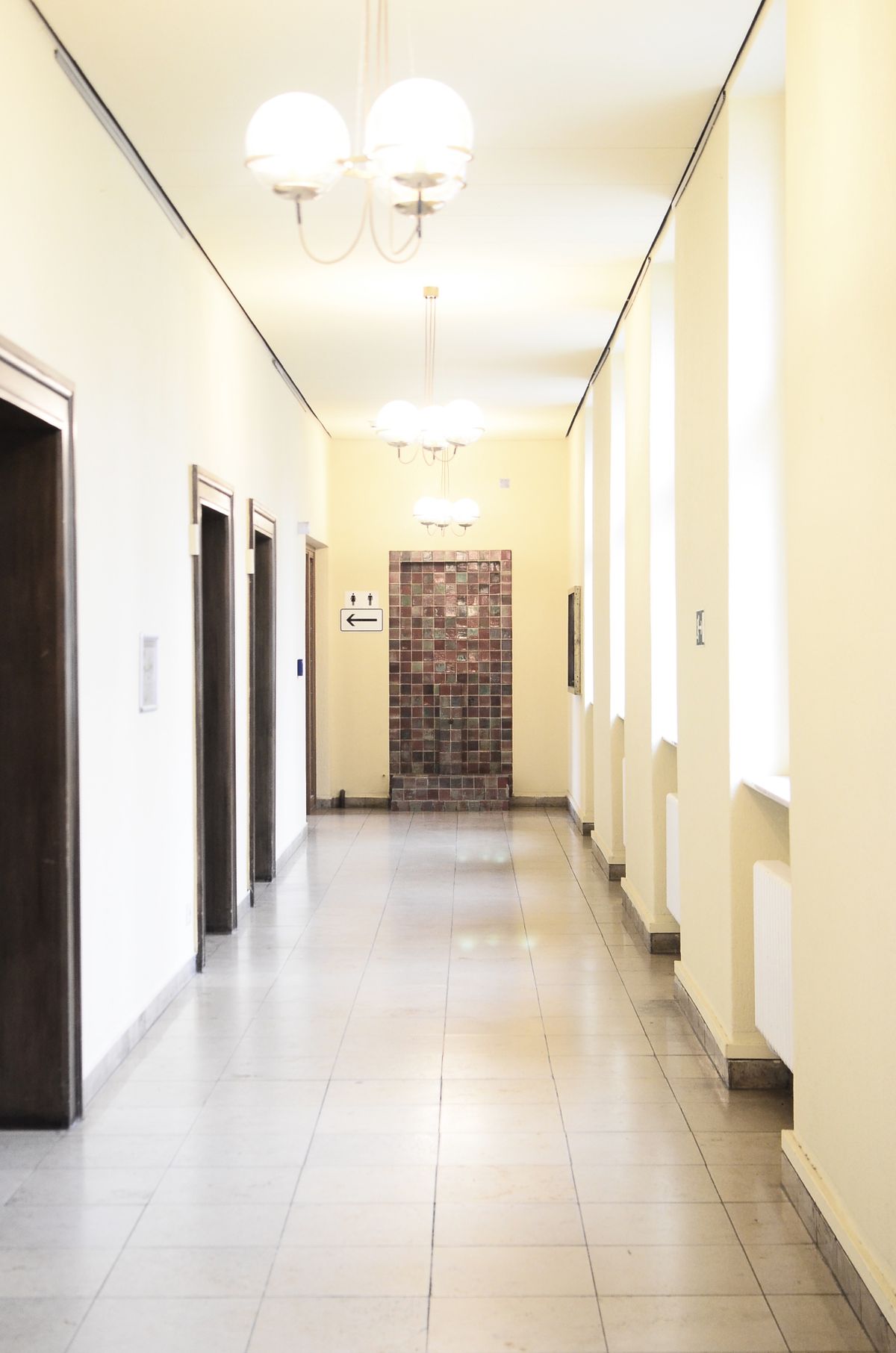 Hotel corridor with guest room doors under soft lighting