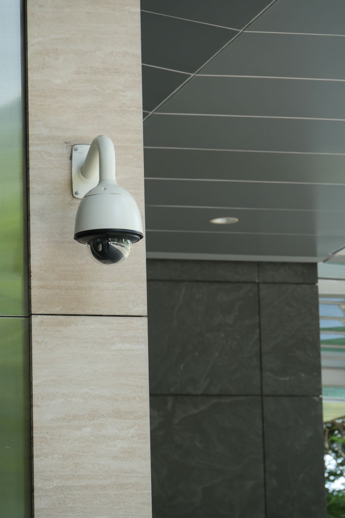 Cámara de vigilancia moderna montada en exterior de edificio para control de acceso