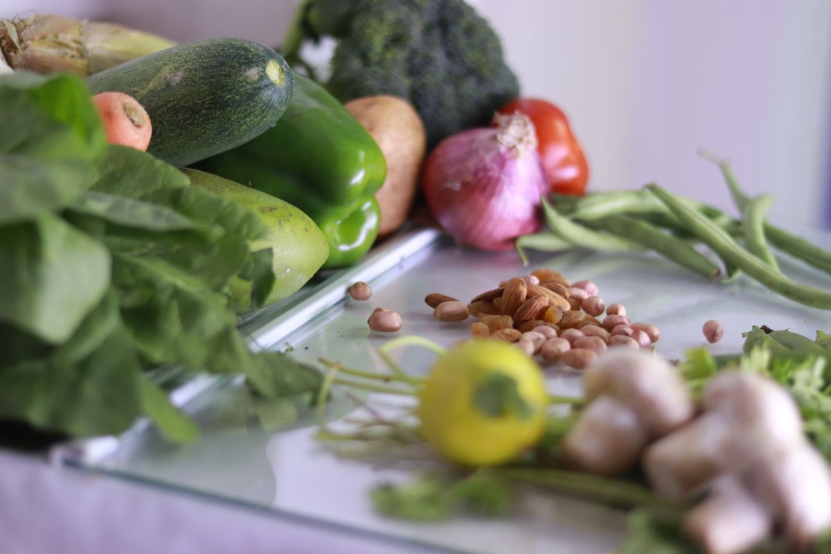 Vegetales frescos y frutos secos sobre una mesa, base de una alimentación baja en histamina