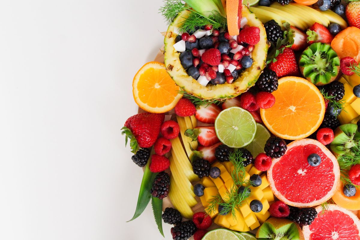 Variedad colorida de frutas y verduras frescas ricas en fibra sobre mesa de madera