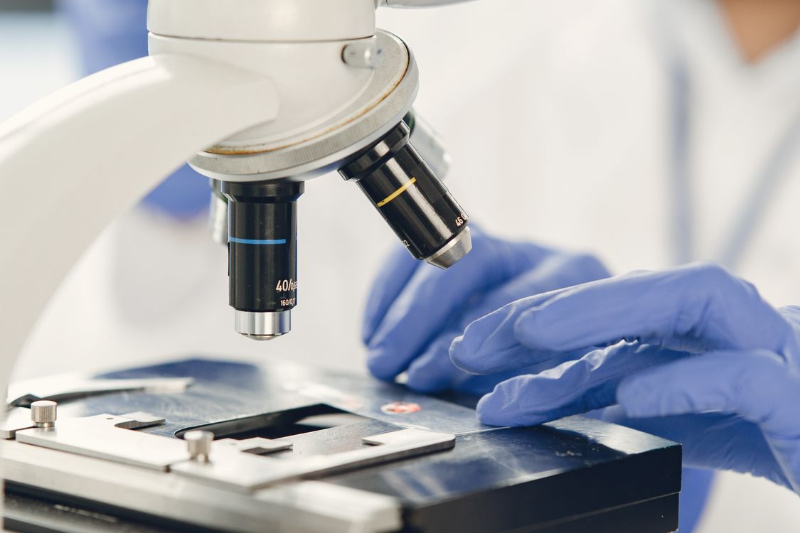 Técnico de laboratorio examinando una muestra bajo el microscopio